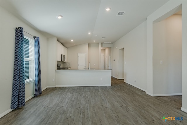 unfurnished living room with lofted ceiling, sink, and light hardwood / wood-style flooring