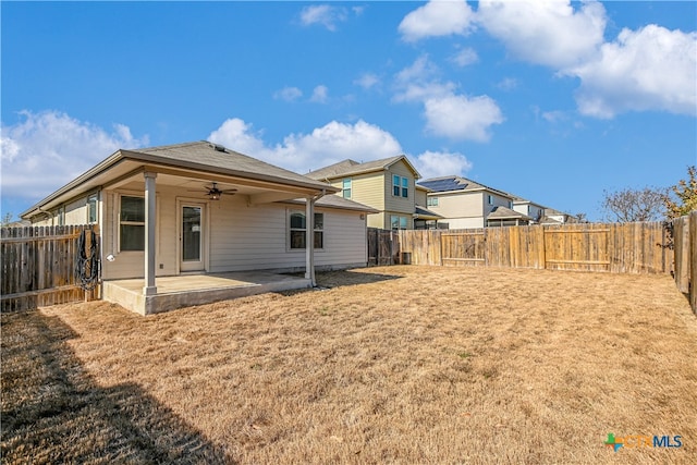 rear view of house with a yard, ceiling fan, and a patio area