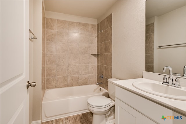 full bathroom with hardwood / wood-style flooring, vanity, toilet, and tiled shower / bath combo