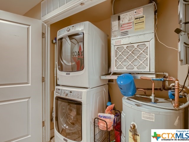 washroom featuring water heater and stacked washer / drying machine