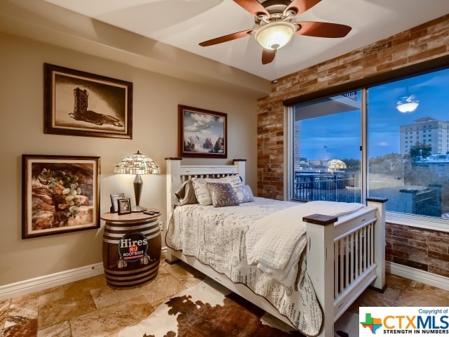 bedroom featuring access to exterior, brick wall, and ceiling fan