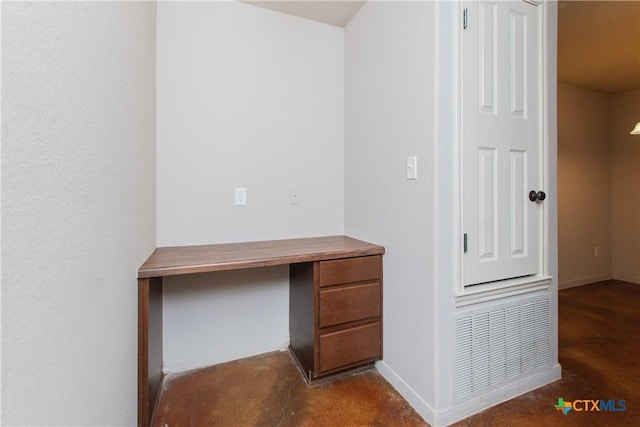 unfurnished office featuring baseboards and unfinished concrete floors