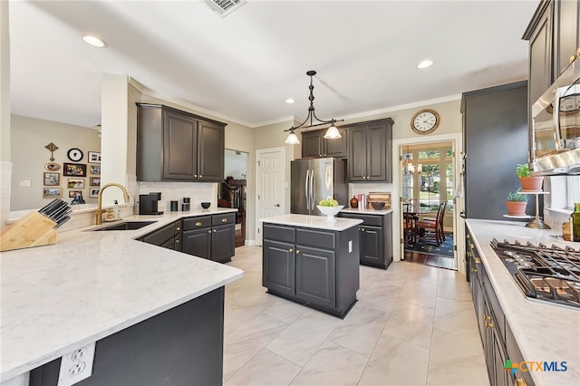 kitchen featuring appliances with stainless steel finishes, a sink, decorative backsplash, decorative light fixtures, and recessed lighting
