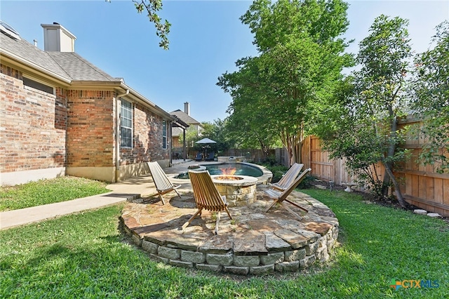 view of yard featuring a fire pit and a patio