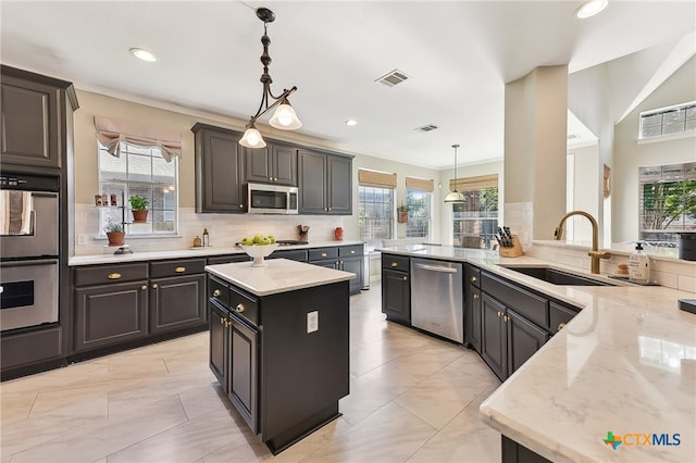 kitchen with stainless steel appliances, a sink, plenty of natural light, recessed lighting, and ornamental molding