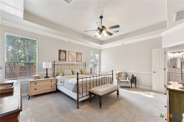 bedroom featuring a raised ceiling, light colored carpet, crown molding, a ceiling fan, and baseboards