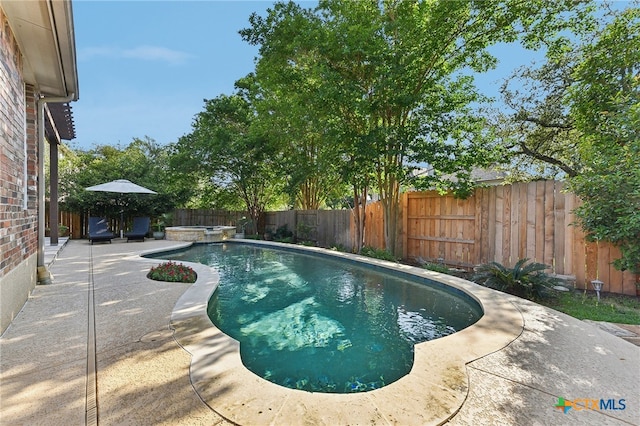 view of pool featuring a fenced backyard, a patio area, and a pool with connected hot tub