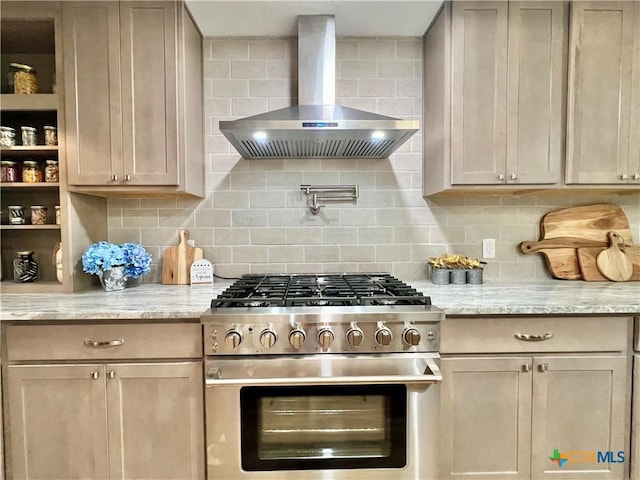 101 Biltmore Dr, Victoria, TX 77904 - kitchen with high end stove, wall chimney range hood, and decorative backsplash
