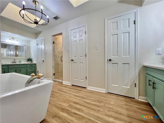 101 Biltmore Dr, Victoria, TX 77904 - bathroom featuring vanity, a shower stall, a chandelier, wood finished floors, and a freestanding bath