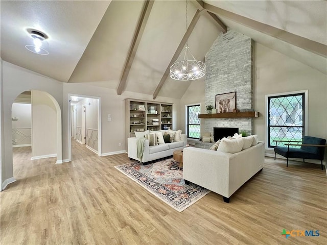 101 Biltmore Dr, Victoria, TX 77904 - living room with high vaulted ceiling, arched walkways, light wood-style flooring, a chandelier, and a fireplace
