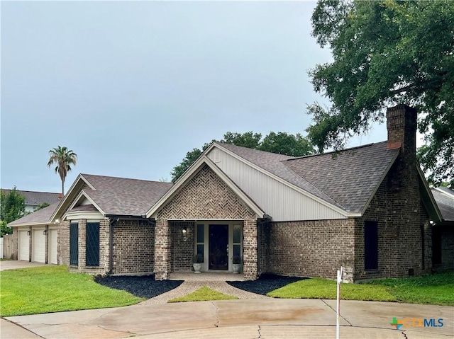 101 Biltmore Dr, Victoria, TX 77904 - ranch-style house featuring brick siding, roof with shingles, driveway, an attached garage, and a front lawn