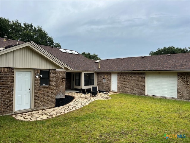 101 Biltmore Dr, Victoria, TX 77904 - rear view of house featuring brick siding, a yard, roof with shingles, and a patio