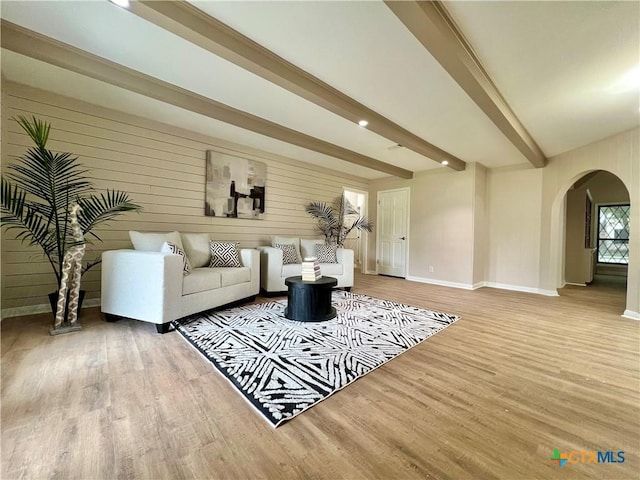 101 Biltmore Dr, Victoria, TX 77904 - living room featuring arched walkways, wood finished floors, beam ceiling, and wood walls