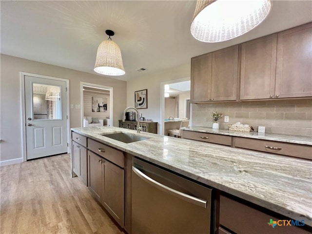 101 Biltmore Dr, Victoria, TX 77904 - kitchen featuring dishwasher, light wood-type flooring, light stone counters, hanging light fixtures, and backsplash