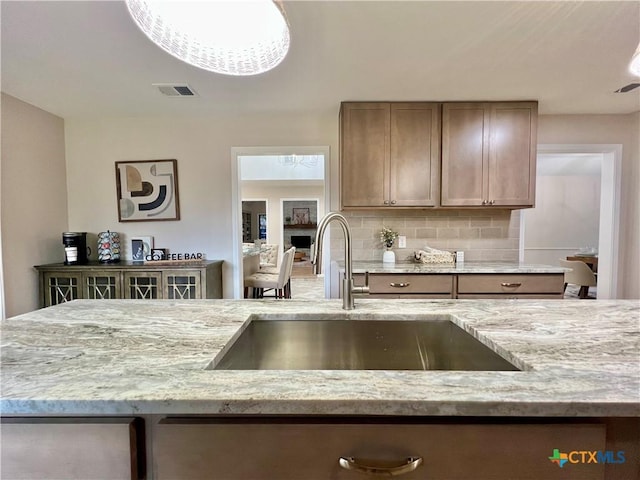 101 Biltmore Dr, Victoria, TX 77904 - kitchen featuring tasteful backsplash and light stone counters