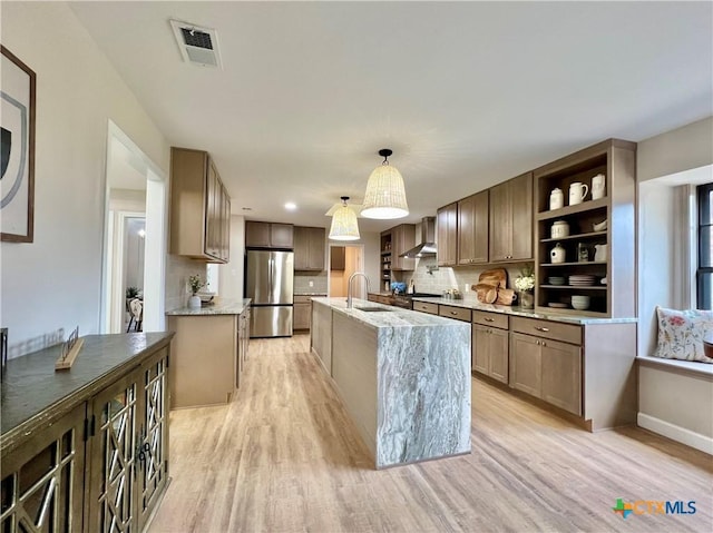 101 Biltmore Dr, Victoria, TX 77904 - kitchen featuring freestanding refrigerator, light wood-type flooring, light stone counters, and open shelves