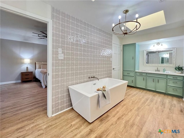 101 Biltmore Dr, Victoria, TX 77904 - ensuite bathroom featuring vanity, wood finished floors, a freestanding bath, and a chandelier