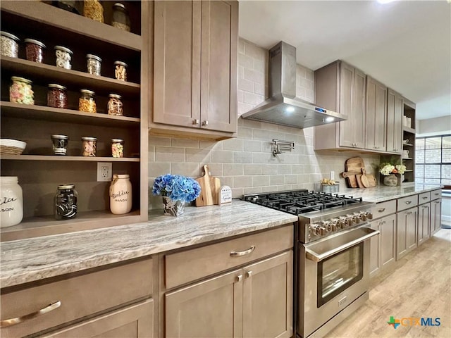 101 Biltmore Dr, Victoria, TX 77904 - kitchen featuring wall chimney range hood, high end stainless steel range oven, open shelves, and light stone counters