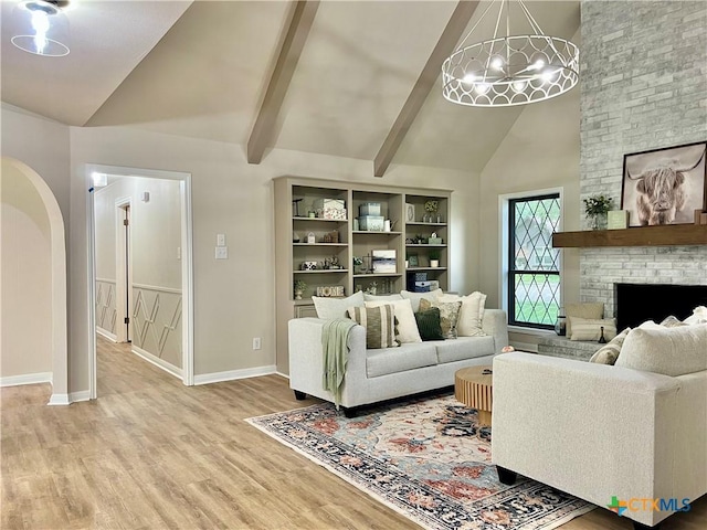 101 Biltmore Dr, Victoria, TX 77904 - living area featuring high vaulted ceiling, a chandelier, wood finished floors, a fireplace, and beam ceiling