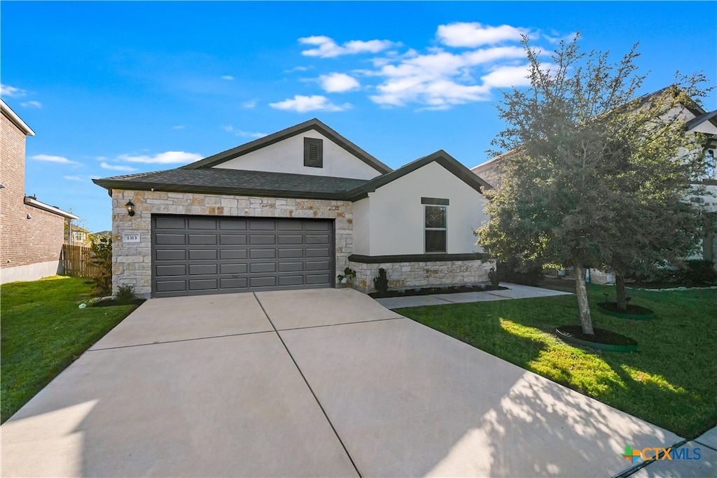 view of front of property with a garage and a front lawn