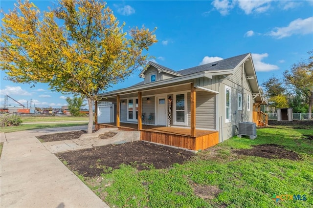 bungalow featuring a porch, central AC unit, and a front lawn