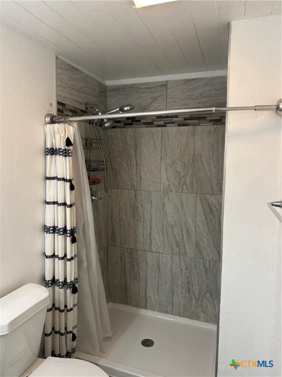 bathroom featuring toilet and a shower with shower curtain