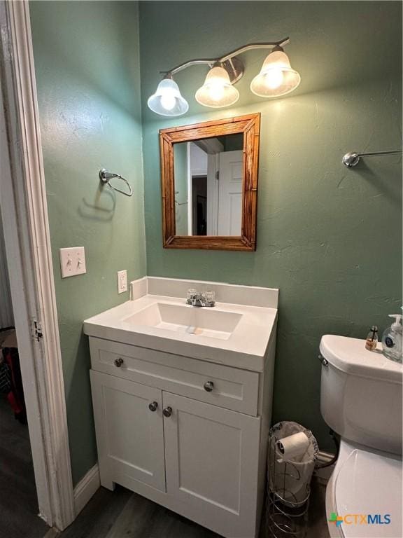 2110 Saunders St, Gatesville, TX 76528 - half bathroom featuring vanity, wood finished floors, toilet, and baseboards
