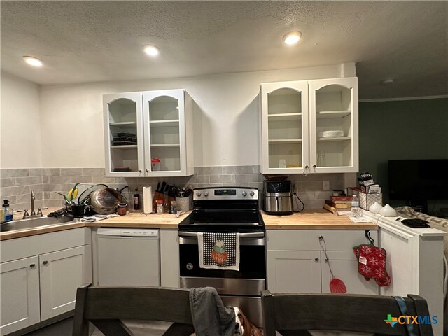 kitchen with electric range, sink, white dishwasher, and white cabinetry