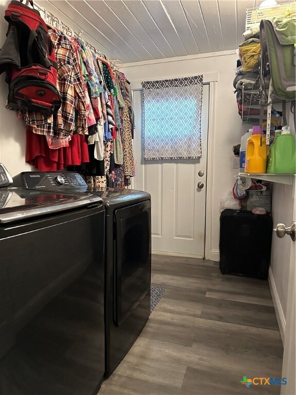 clothes washing area with wooden ceiling, washer and dryer, ornamental molding, and hardwood / wood-style floors