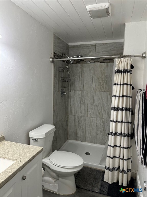 bathroom featuring toilet, wood ceiling, a shower with curtain, and vanity