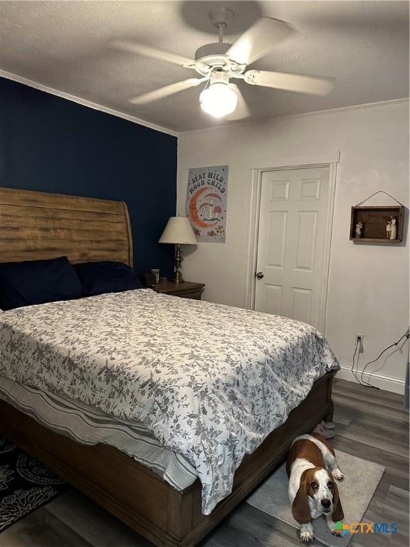 bedroom with ceiling fan, a textured ceiling, dark hardwood / wood-style floors, and crown molding