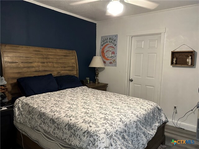 bedroom with ceiling fan, dark hardwood / wood-style floors, and ornamental molding