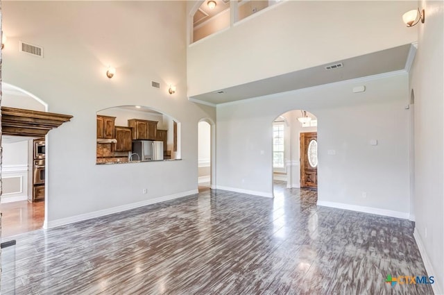 2508 Mugho Dr, Harker Heights, TX 76548 - unfurnished living room with wood finished floors, arched walkways, and a high ceiling