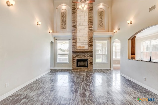 2508 Mugho Dr, Harker Heights, TX 76548 - unfurnished living room with a high ceiling, healthy amount of natural light, wood finished floors, and a brick fireplace