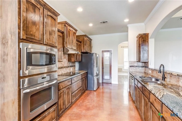 2508 Mugho Dr, Harker Heights, TX 76548 - kitchen featuring appliances with stainless steel finishes, backsplash, stone counters, arched walkways, and ornamental molding
