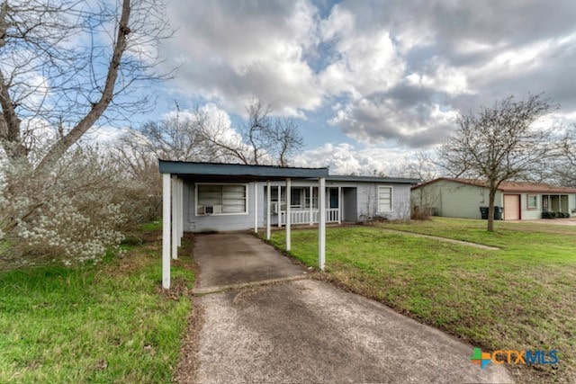 ranch-style home featuring a carport and a front yard