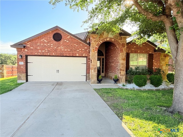 6909 Modesto Rd, Killeen, TX 76542 - traditional home with a garage, brick siding, stone siding, and driveway
