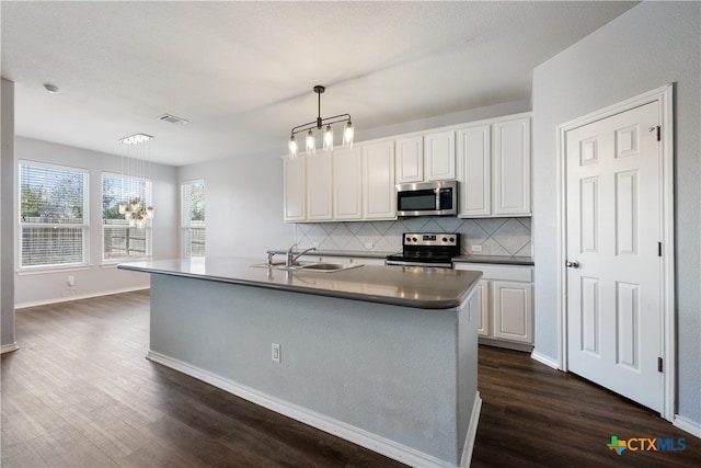 kitchen with stainless steel appliances, white cabinetry, hanging light fixtures, and sink