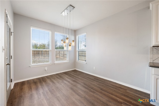 unfurnished dining area with dark hardwood / wood-style flooring and plenty of natural light