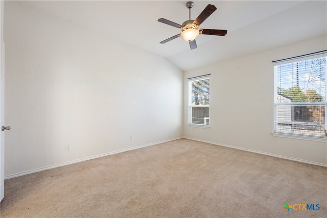 carpeted spare room featuring ceiling fan and lofted ceiling