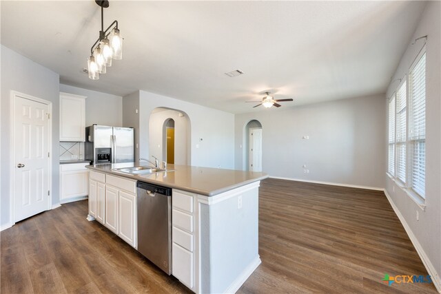 kitchen featuring a kitchen island with sink, sink, appliances with stainless steel finishes, decorative light fixtures, and white cabinetry