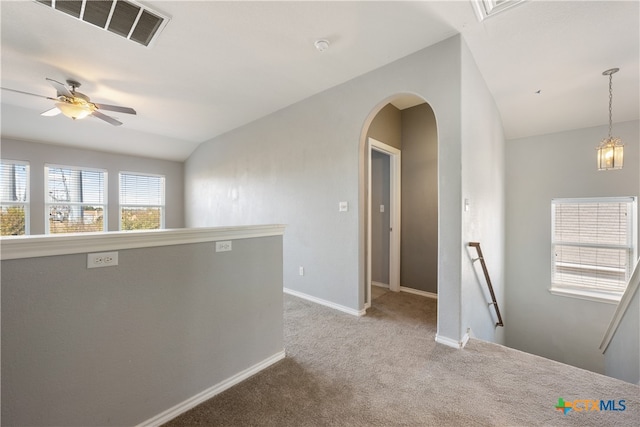 unfurnished room featuring a wealth of natural light, carpet floors, lofted ceiling, and ceiling fan