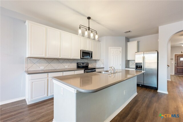 kitchen with dark wood-type flooring, white cabinets, pendant lighting, and appliances with stainless steel finishes