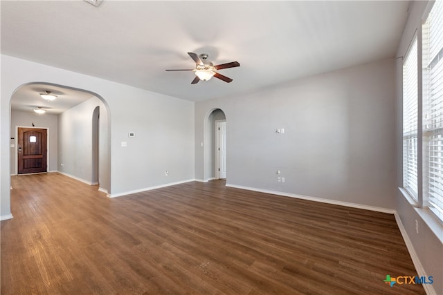 empty room with dark hardwood / wood-style flooring and ceiling fan