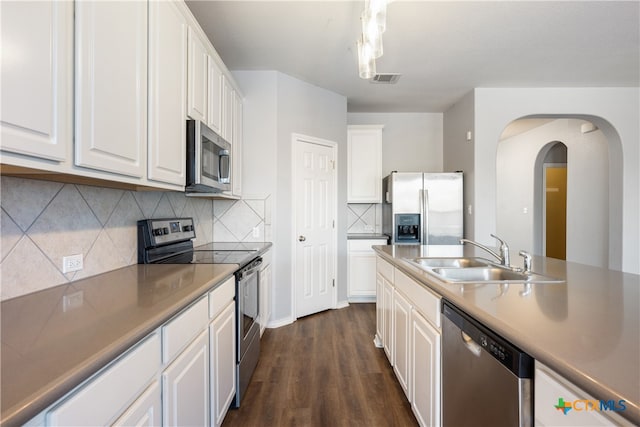 kitchen featuring backsplash, sink, dark hardwood / wood-style flooring, white cabinetry, and stainless steel appliances