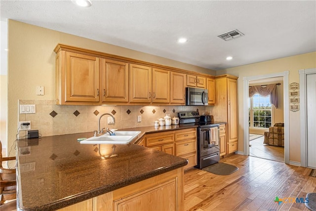 444 E Maxwell Ditch Rd, Port Lavaca, TX 77979 - kitchen with stainless steel appliances, a peninsula, tasteful backsplash, light wood finished floors, and recessed lighting
