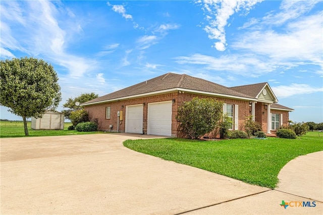 444 E Maxwell Ditch Rd, Port Lavaca, TX 77979 - view of front of property with brick siding, a front yard, an attached garage, concrete driveway, and a storage unit