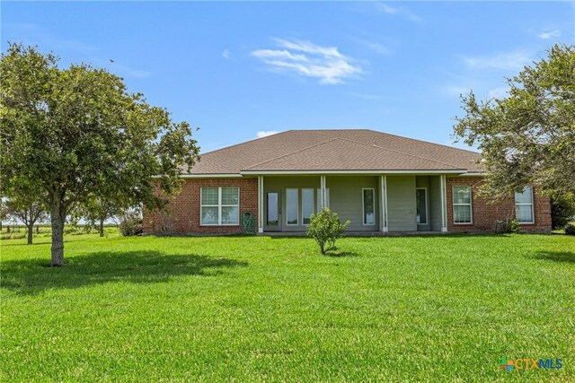 444 E Maxwell Ditch Rd, Port Lavaca, TX 77979 - back of house featuring a yard, brick siding, and roof with shingles