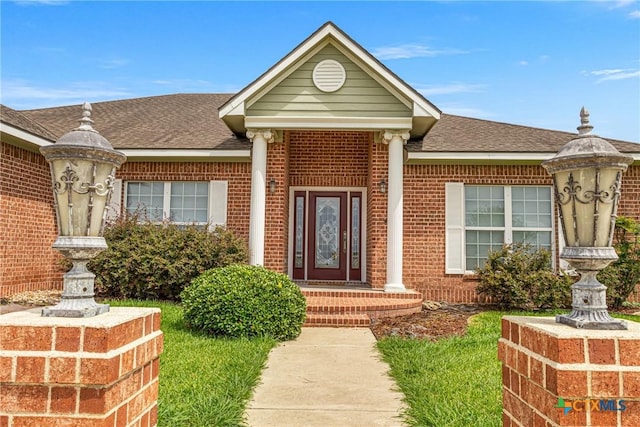444 E Maxwell Ditch Rd, Port Lavaca, TX 77979 - view of exterior entry featuring brick siding and a shingled roof