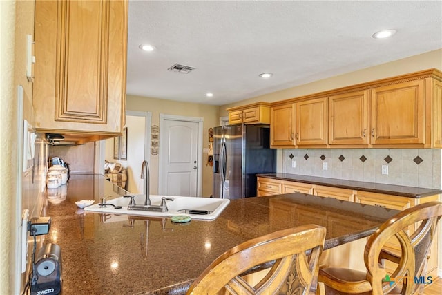 444 E Maxwell Ditch Rd, Port Lavaca, TX 77979 - kitchen featuring stainless steel fridge with ice dispenser, a breakfast bar area, tasteful backsplash, a peninsula, and recessed lighting